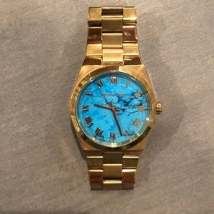 Women’s Michael Kors watch with gold band and turquoise face. Needs new battery